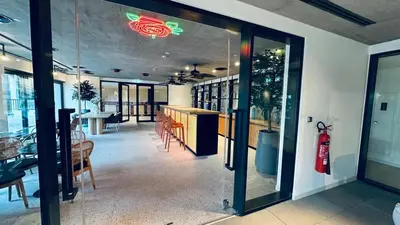 a room with a table and chairs and a glass door at Studio Hotel Apartment Brand New Azizi Riv 14 in Dubai