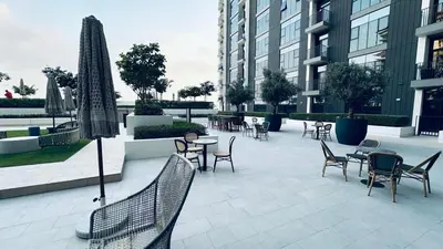 a patio with chairs and tables in a building at Studio Hotel Apartment Brand New Azizi Riv 14 in Dubai
