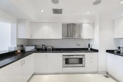 a white kitchen with white cabinets and appliances at Oceana Baltic Palm West Beach Views 3 bd Sleeps 7 in Dubai