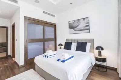 a bedroom with a large white bed with a window at Oceana Baltic Palm West Beach Views 3 bd Sleeps 7 in Dubai