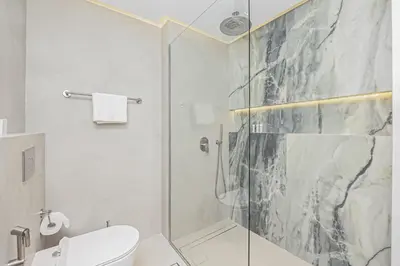 a bathroom with a glass shower with a toilet at Luxury at Beachside Al Sultana Jumeirah Shoreline - DVH Holiday Homes in Dubai