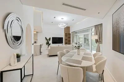 a living room with a white table and chairs at Luxury at Beachside Al Sultana Jumeirah Shoreline - DVH Holiday Homes in Dubai