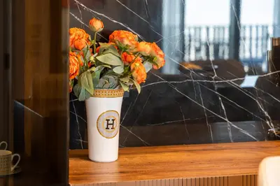 a white vase filled with orange flowers on a table at Luxury Apartment at Dubai Creek Harbour, Bayshore - By DuStay in Dubai