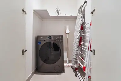 a washer and dryer in a laundry room at Stylish Poolside Apartment in Dubai Creek Harbour - By DuStay in Dubai