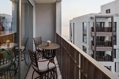 a balcony with a table and chairs and a view of a building at Stylish Poolside Apartment in Dubai Creek Harbour - By DuStay in Dubai
