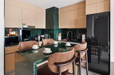 a kitchen with a counter with chairs and a table at Stylish Poolside Apartment in Dubai Creek Harbour - By DuStay in Dubai