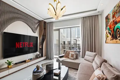 a living room with a couch and a tv at Luxury Getaway Apartment at Dubai Creek Harbour - By Dustay in Dubai