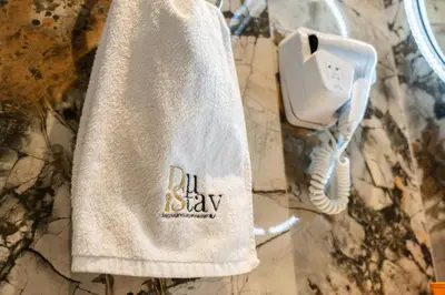 a white towel hanging on a wall with a phone at Luxury Getaway Apartment at Dubai Creek Harbour - By Dustay in Dubai