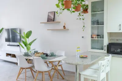 a dining room with a table and white chairs at StayShort - Cozy 1-Bedroom Apartment for 5 in Motor City! in Dubai