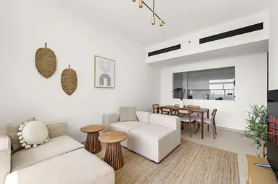 a living room with a couch and a table at Vayk - Modern 2BR Apartment in Dubai