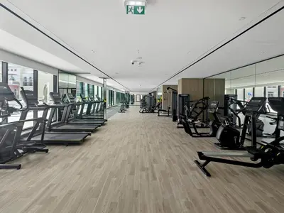 a gym with a row of treadmills and machines at Vayk - Modern 2BR Apartment in Dubai