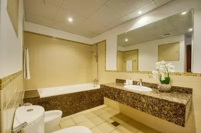 a bathroom with a toilet and a sink and a tub at The Smart Concierge - Bahar 6 in Dubai