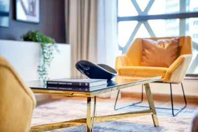 a living room with a glass table and a chair at The Smart Concierge - Bahar 6 in Dubai