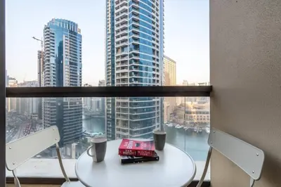 a table and chairs in front of a large window at The Smart Concierge - Bahar 6 in Dubai