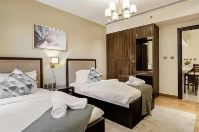 a hotel room with two beds and a table at Cozy 2BR in Elite Downtown Residence with Canal view in Dubai