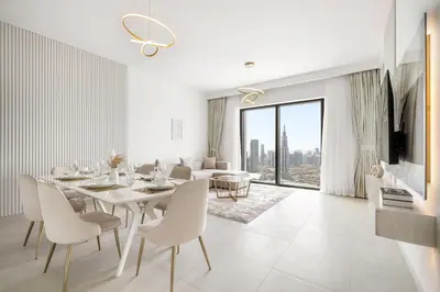 a white dining room with a table and chairs at Peaceful Dunes 1 - Burj Khalifa & Dubai Mall in Dubai
