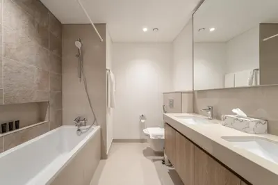 a bathroom with two sinks and a tub and a toilet at Peaceful Dunes 1 - Burj Khalifa & Dubai Mall in Dubai