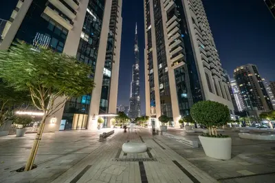 a city street with tall buildings and a bench and trees at Peaceful Dunes 2 - Near Burj Khalifa & Dubai Mall in Dubai