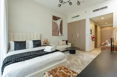 a bedroom with a large bed and a living room at Nasma Luxury Stays - Azizi Riviera 6 Cozy Studio with Burj Khalifa View in Dubai