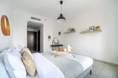 a bedroom with a white bed with a table on it at Frank Porter - Marina Quays West Tower in Dubai