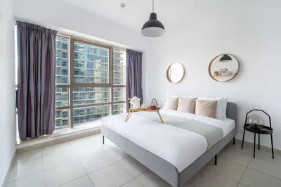 a bedroom with a large bed with a large window at Frank Porter - Marina Quays West Tower in Dubai