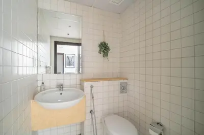 a white tiled bathroom with a sink and a toilet at Frank Porter - Marina Quays West Tower in Dubai