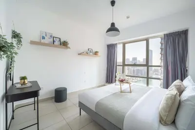 a bedroom with a bed and a desk and a window at Frank Porter - Marina Quays West Tower in Dubai