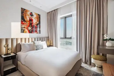 a bedroom with a white bed and a large window at Elegant 2-Bedroom Apartment in Dubai Creek Harbour - By Dustay in Dubai