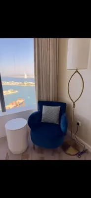 a blue chair in a room with a window at Gorgeous Palm View in Dubai