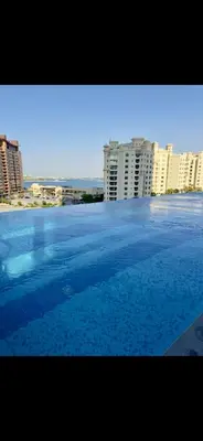 a large swimming pool in front of some buildings at Gorgeous Palm View in Dubai