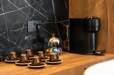 a row of cups on a counter next to a coffee maker at Family Friendly luxurious Waterfront Apartment - By Dustay in Dubai