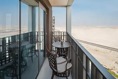 a balcony with tables and chairs and a view of the beach at Family Friendly luxurious Waterfront Apartment - By Dustay in Dubai