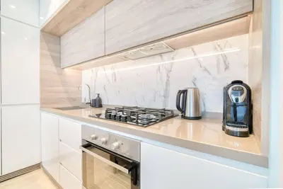 a kitchen with a stove and a microwave at 5 Mins to JBR Beach, Luxury Studio in Dubai Marina's Best Tower in Dubai