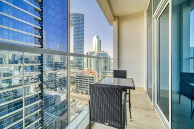 a balcony with a desk and a view of a city at 5 Mins to JBR Beach, Luxury Studio in Dubai Marina's Best Tower in Dubai