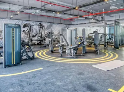 a gym with several tread machines and a wall with graffiti at 5 Mins to JBR Beach, Luxury Studio in Dubai Marina's Best Tower in Dubai