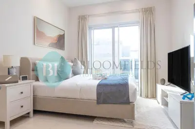 a bedroom with a bed and a large window at Bloomfields Cozy Studio In Hera Tower Dubai in Dubai