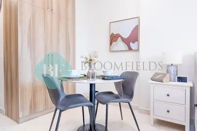 a dining room with a table and two chairs at Bloomfields Cozy Studio In Hera Tower Dubai in Dubai