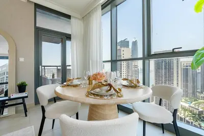 a dining room with a table and chairs and windows at Skyline Huge 1 Bedroom Apartment Creek in Dubai