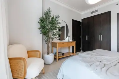 a bedroom with a bed and a potted tree in it at Skyline Huge 1 Bedroom Apartment Creek in Dubai