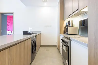 a kitchen with a washer and dryer and a microwave at Stella Maris, Dubai Marina- Luxurious 1-BR in Dubai