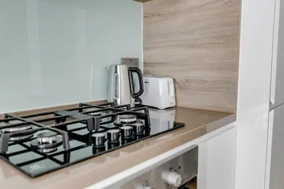 a kitchen with a stove top and a microwave at Knokey Dubai Marina Comfortable Apartments with Pool and Gym in Dubai