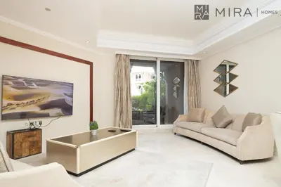 a living room with a couch and a table at Mira Holiday Homes - Spacious 2 bedroom with patio in Palm Jumeirah in Dubai