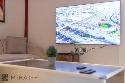 a living room with a tv hanging on the wall at Mira Holiday Homes - Spacious 2 bedroom with patio in Palm Jumeirah in Dubai