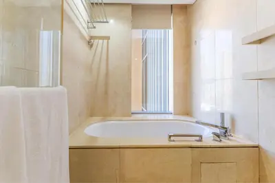 a bathroom with a bath tub and a window at HAVN - Studio Dubai Marina View in Dubai