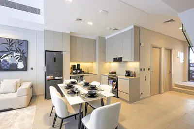 a kitchen and living room with a table and chairs at Mag Eye Townhouse - 2BR & M Room Townhouse - Allsopp & Allsopp in Dubai