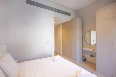 a bedroom with a white bed and a mirror at Mag Eye Townhouse - 2BR & M Room Townhouse - Allsopp & Allsopp in Dubai