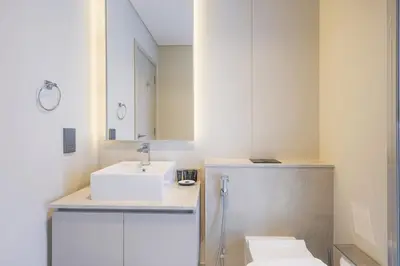 a white bathroom with a sink and a mirror at Mag Eye Townhouse - 2BR & M Room Townhouse - Allsopp & Allsopp in Dubai