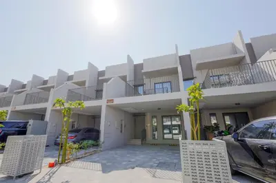 a building with cars parked in a parking lot at Mag Eye Townhouse - 2BR & M Room Townhouse - Allsopp & Allsopp in Dubai
