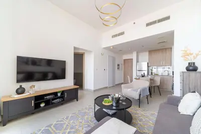 a living room with a couch and a tv at Frank Porter - Parkside Rawda 4 in Dubai