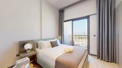 a bedroom with a bed with a large window at Mag Eye 910 - Tranquil Studio Apartment in Meydan in Dubai